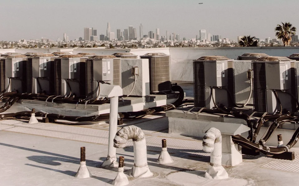 Multiple rooftop HVAC units and mechanical pipework on a commercial building
