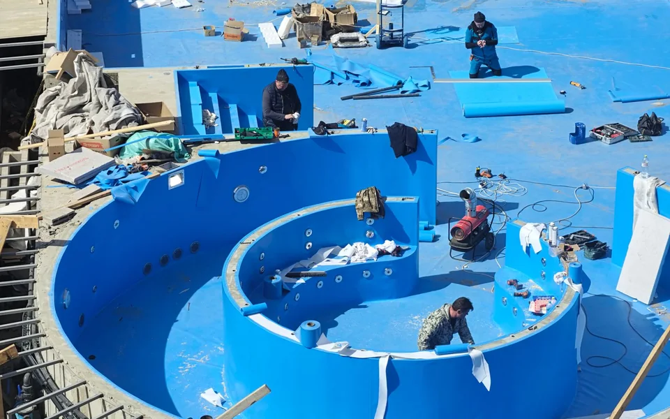 Workers preparing an empty pool basin