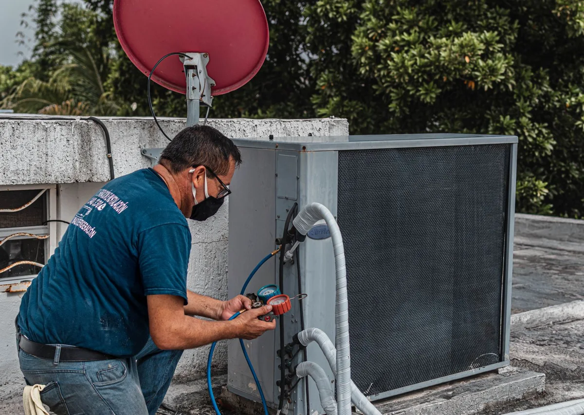HVAC technician servicing an outdoor air conditioning unit